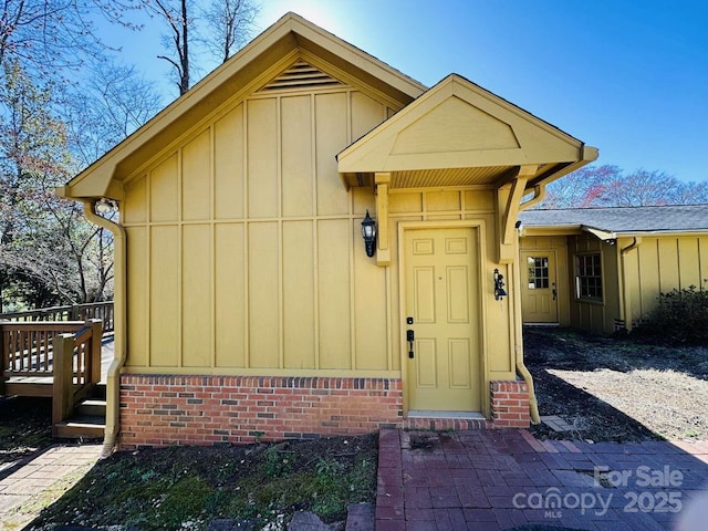 entrance to property featuring brick siding and board and batten siding