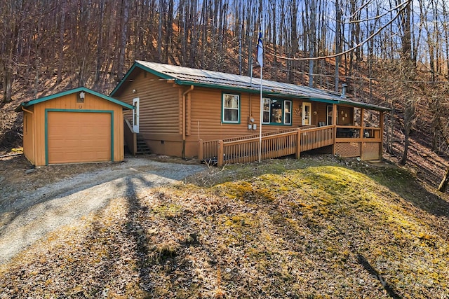 rustic home with log veneer siding, driveway, an outdoor structure, a garage, and metal roof