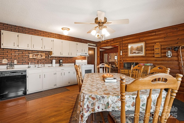 kitchen with a sink, black appliances, light countertops, under cabinet range hood, and a textured ceiling