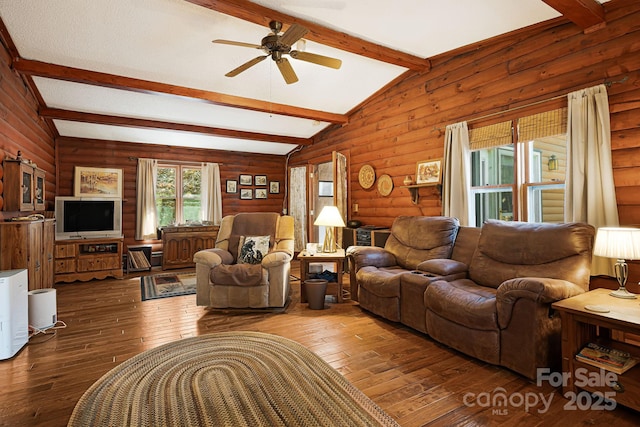 living area with lofted ceiling with beams, hardwood / wood-style floors, and a ceiling fan