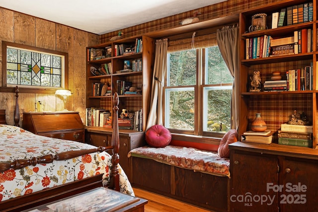 bedroom with wooden walls and wood finished floors