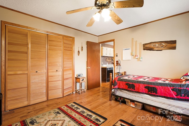 bedroom featuring a closet, light wood-style flooring, and crown molding