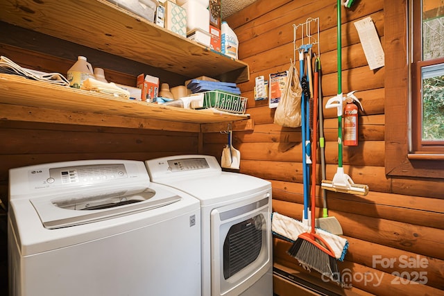 clothes washing area with laundry area, separate washer and dryer, and rustic walls