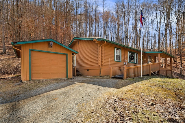 view of front of property featuring an outdoor structure, a detached garage, driveway, and crawl space