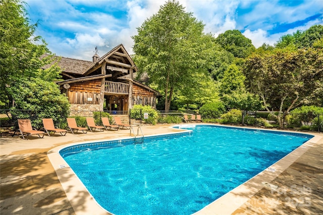 community pool featuring a patio area and fence