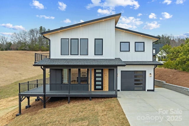 contemporary home featuring a front lawn, board and batten siding, driveway, and a shingled roof