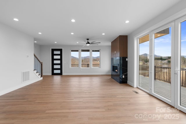 unfurnished living room featuring plenty of natural light, recessed lighting, visible vents, and a tile fireplace