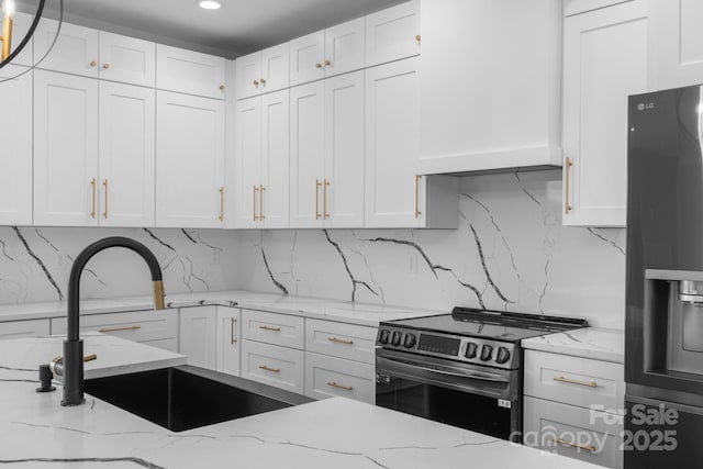 kitchen with a sink, electric stove, white cabinetry, refrigerator with ice dispenser, and tasteful backsplash