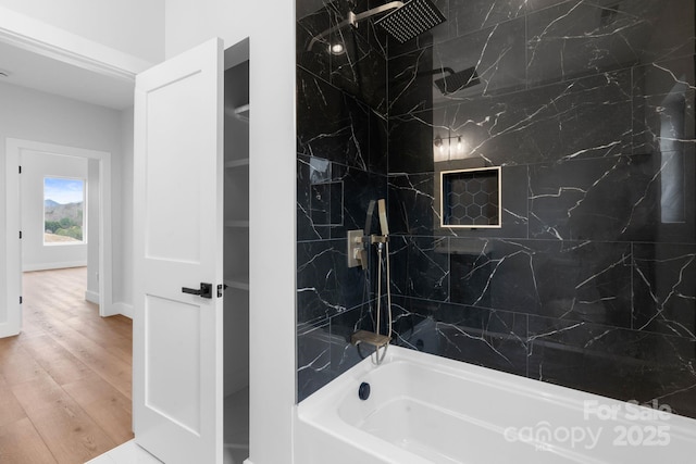 bathroom featuring shower / bath combination, baseboards, and wood finished floors