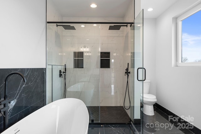 full bathroom featuring a freestanding tub, recessed lighting, a shower stall, toilet, and marble finish floor