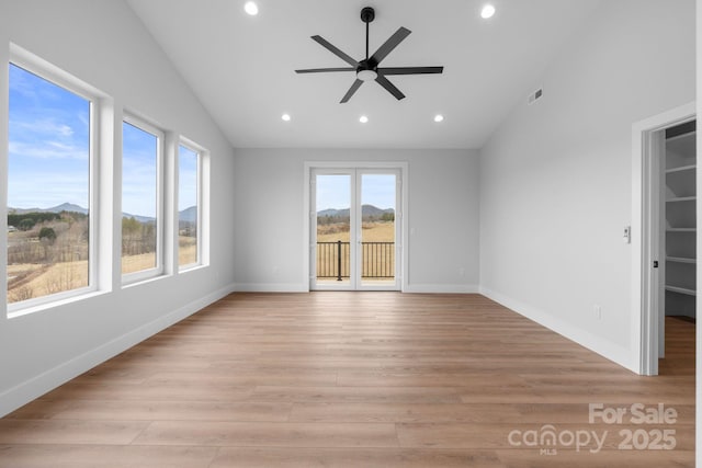 unfurnished room with vaulted ceiling, recessed lighting, baseboards, and light wood finished floors