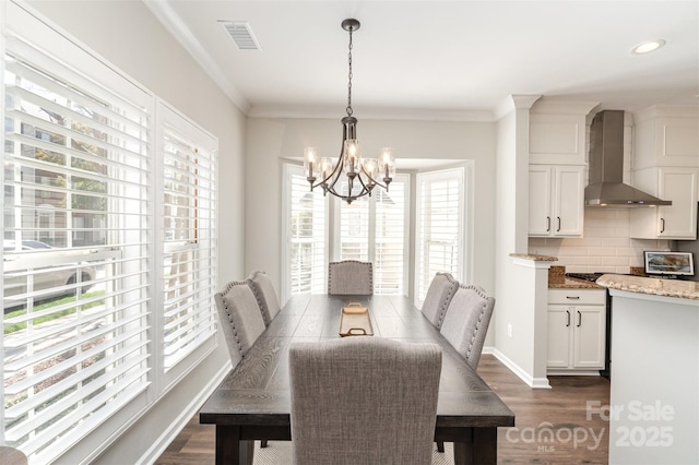 dining area with visible vents, dark wood finished floors, an inviting chandelier, crown molding, and baseboards