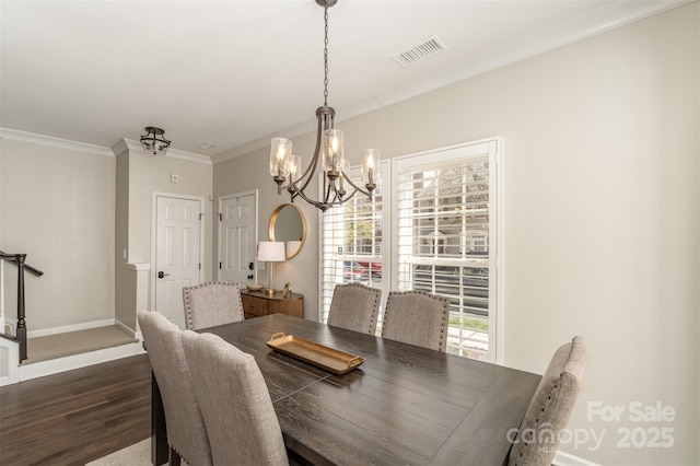 dining room featuring baseboards, visible vents, ornamental molding, dark wood-type flooring, and a chandelier