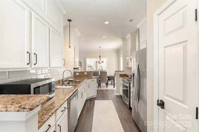 kitchen with a sink, tasteful backsplash, stainless steel appliances, white cabinets, and dark wood-style flooring