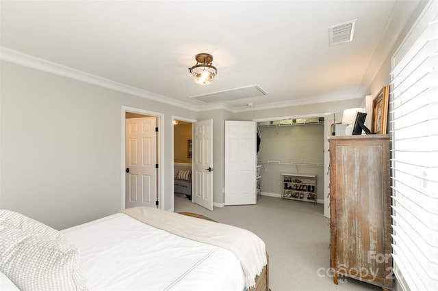 carpeted bedroom with visible vents, attic access, ornamental molding, and a closet