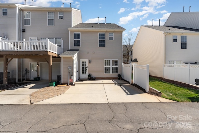 back of property featuring central air condition unit, an attached garage, driveway, and fence