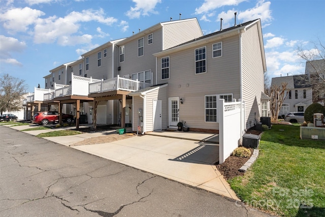 rear view of house featuring a yard, a residential view, and central AC