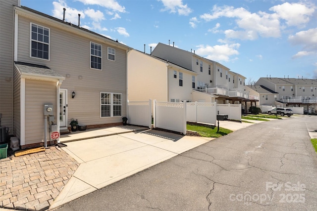 back of property featuring a residential view, a patio, and fence