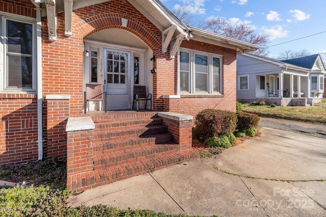 view of exterior entry featuring brick siding