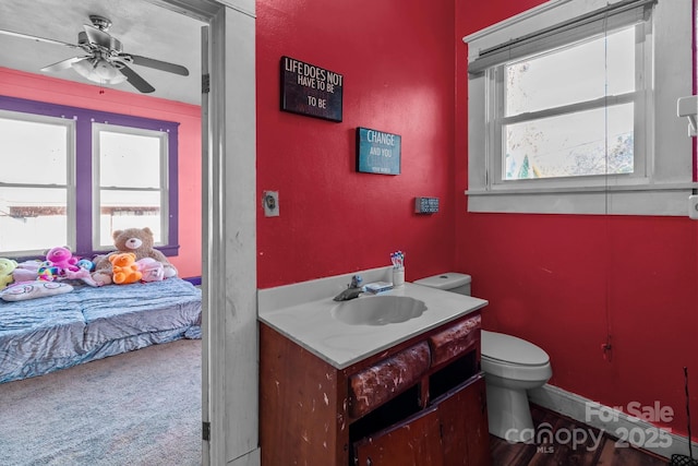 bathroom with vanity, toilet, a ceiling fan, and a wealth of natural light