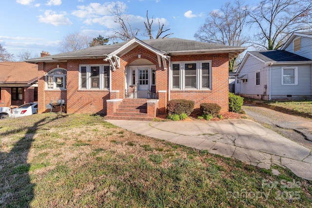 bungalow with brick siding and a front yard