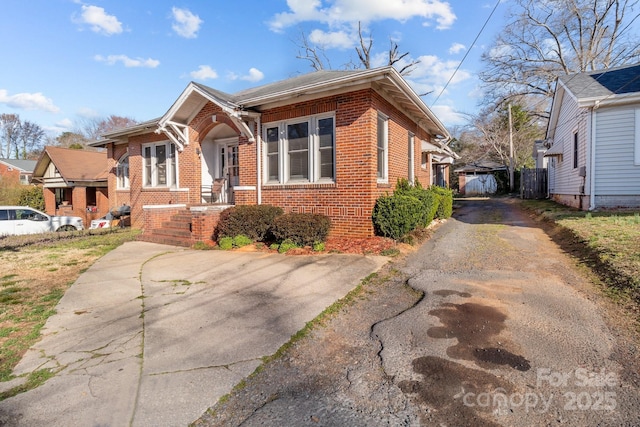 bungalow-style house with brick siding and aphalt driveway