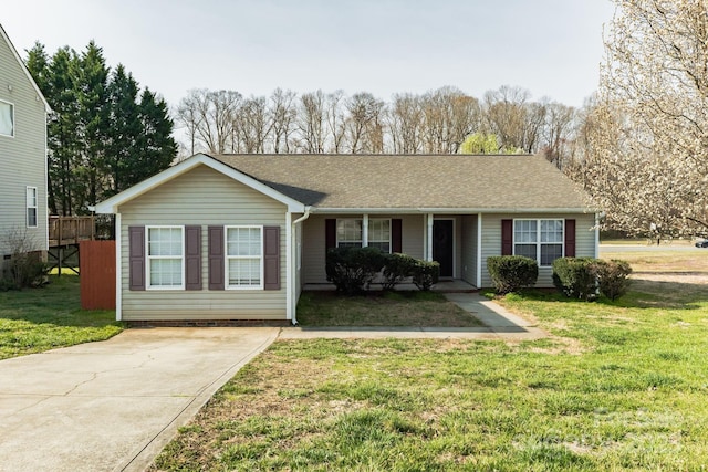 ranch-style house featuring roof with shingles and a front yard