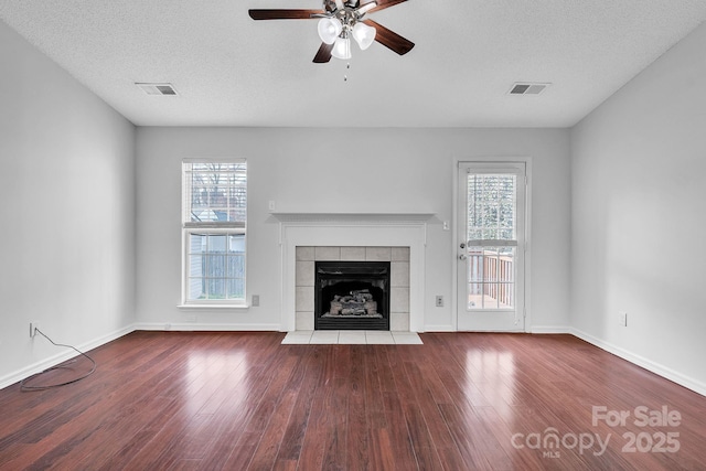 unfurnished living room featuring wood finished floors, visible vents, and ceiling fan