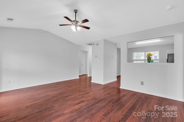 unfurnished room featuring visible vents, a ceiling fan, wood finished floors, baseboards, and vaulted ceiling