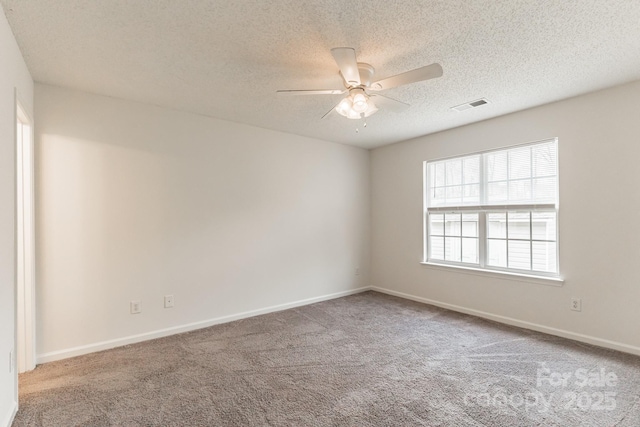 unfurnished room with visible vents, a textured ceiling, carpet, baseboards, and ceiling fan