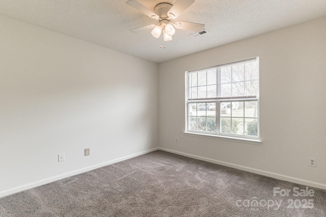 carpeted spare room with baseboards, a ceiling fan, visible vents, and a textured ceiling