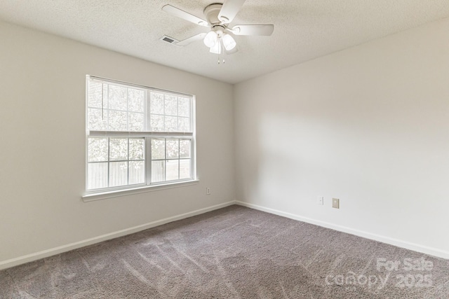 carpeted spare room with baseboards, visible vents, a textured ceiling, and a ceiling fan