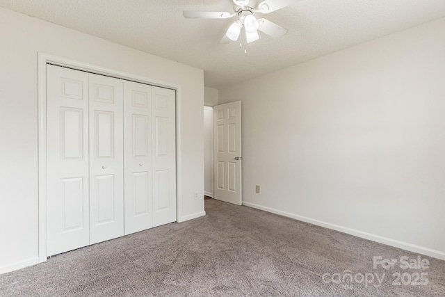 unfurnished bedroom with baseboards, a closet, carpet floors, and a textured ceiling