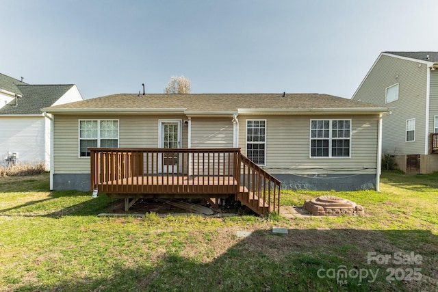 back of property featuring a wooden deck and a yard