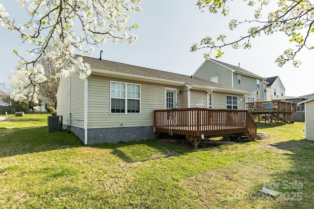 rear view of property with cooling unit, a yard, and a deck