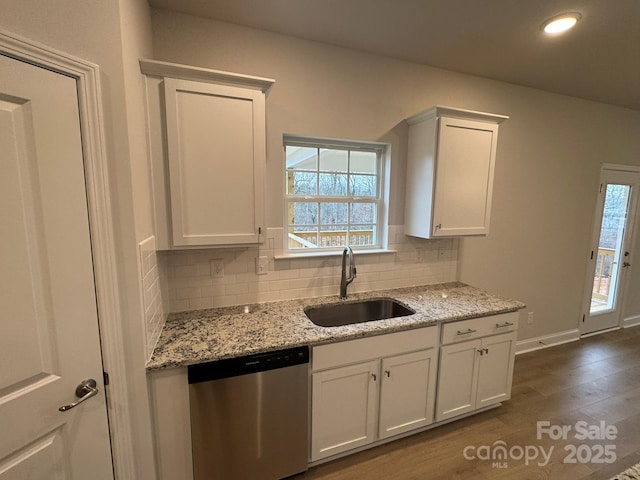 kitchen featuring a sink, dishwasher, decorative backsplash, white cabinetry, and dark wood-style flooring