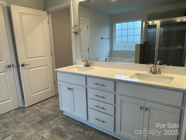 full bath with a sink, a garden tub, double vanity, and a shower stall