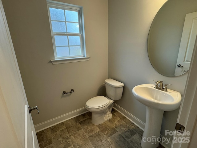 bathroom featuring baseboards and toilet