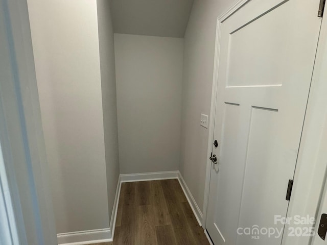 hall featuring baseboards and dark wood-type flooring