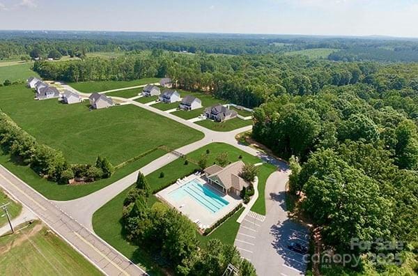 drone / aerial view with a wooded view