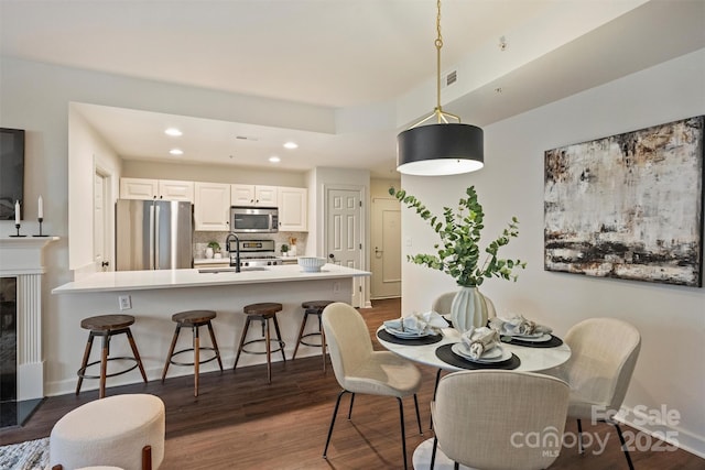 dining room with dark wood finished floors, recessed lighting, visible vents, and baseboards