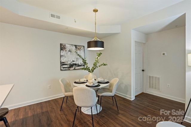 dining room featuring visible vents, baseboards, and wood finished floors