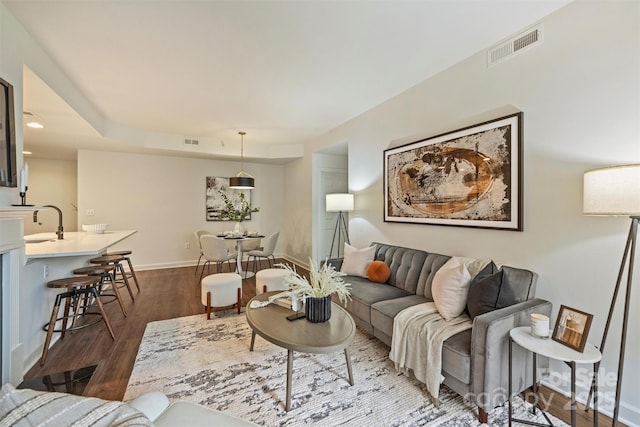 living area featuring visible vents, baseboards, and dark wood-style flooring