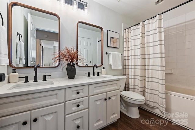 bathroom featuring shower / tub combo, toilet, wood finished floors, and a sink