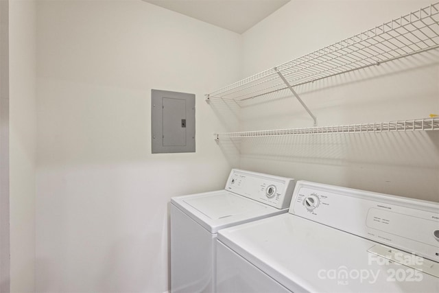 washroom featuring electric panel, laundry area, and washer and dryer