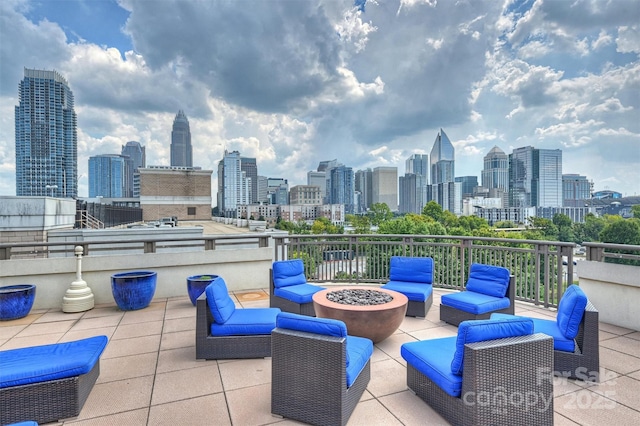 view of patio featuring a view of city and an outdoor living space with a fire pit