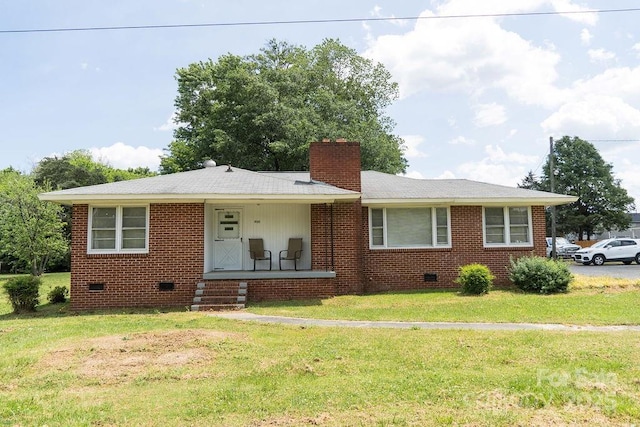 ranch-style home featuring a chimney, brick siding, a front lawn, and crawl space