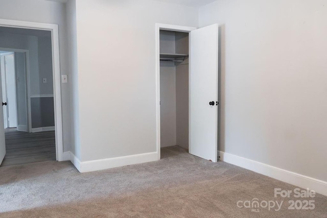 unfurnished bedroom with carpet flooring, a closet, and baseboards