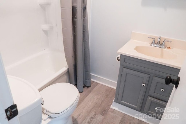 full bathroom featuring toilet, baseboards, wood finished floors, and vanity