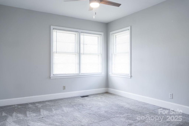 carpeted spare room with plenty of natural light, baseboards, and a ceiling fan